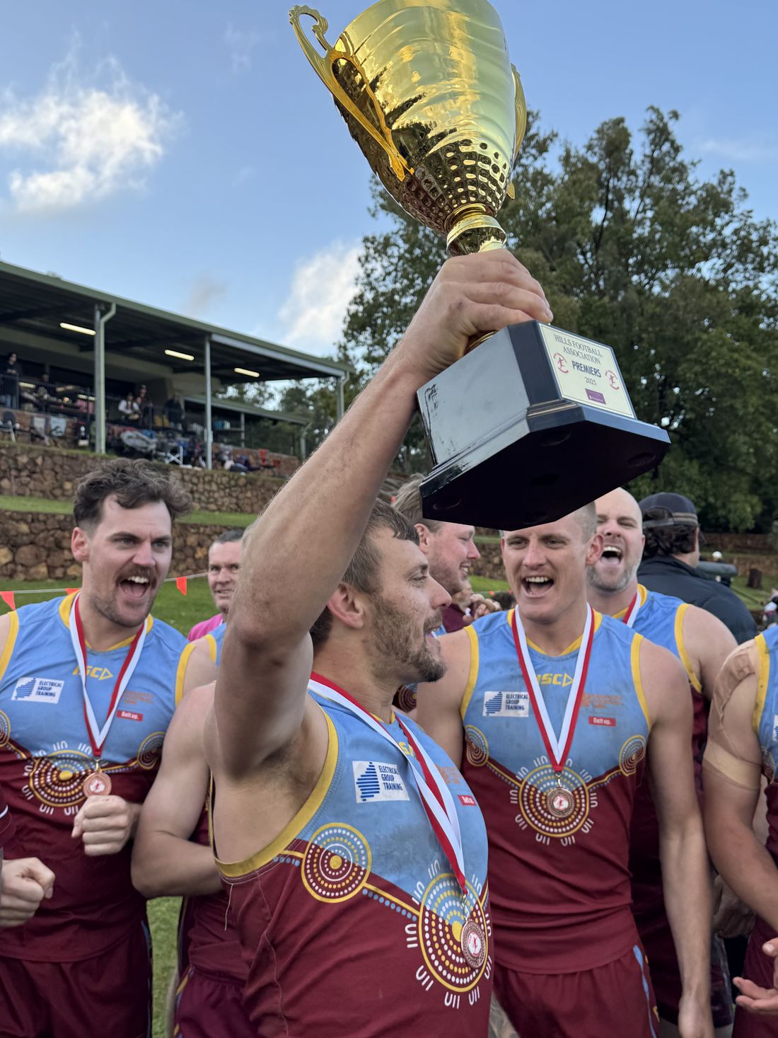 A Swan View player holding the premiership cup high