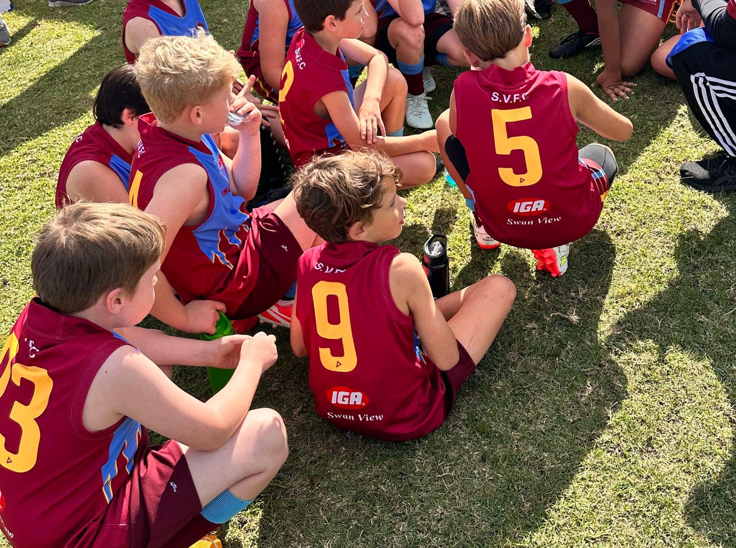 Junior players gathered around their coach after a game