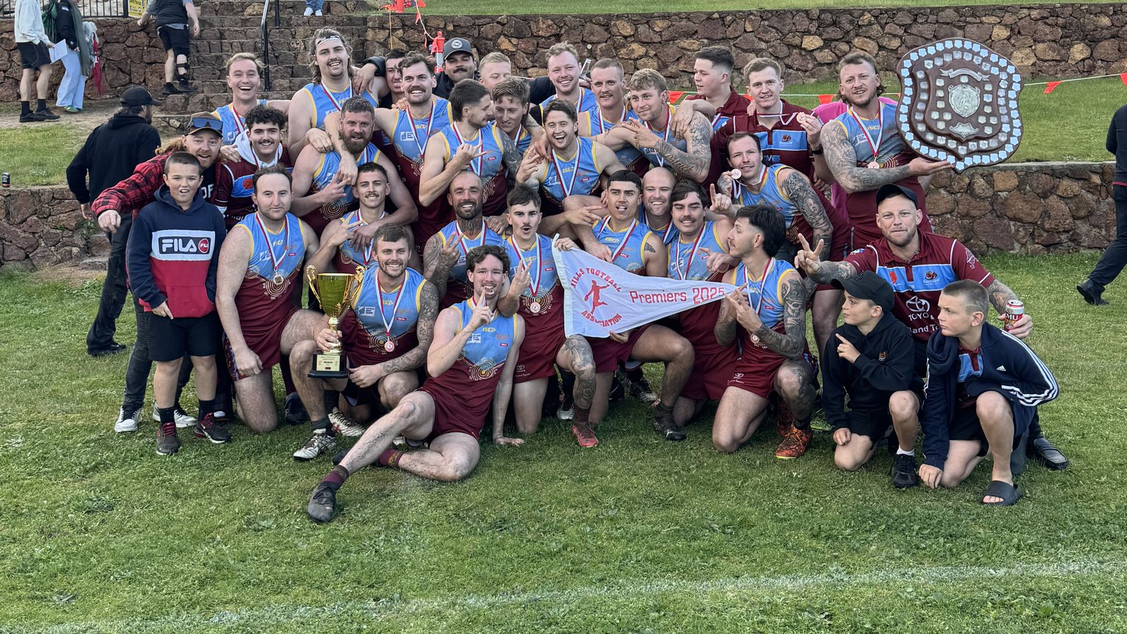 League premiers 2025 with the cup, the shield and a premiers pennant